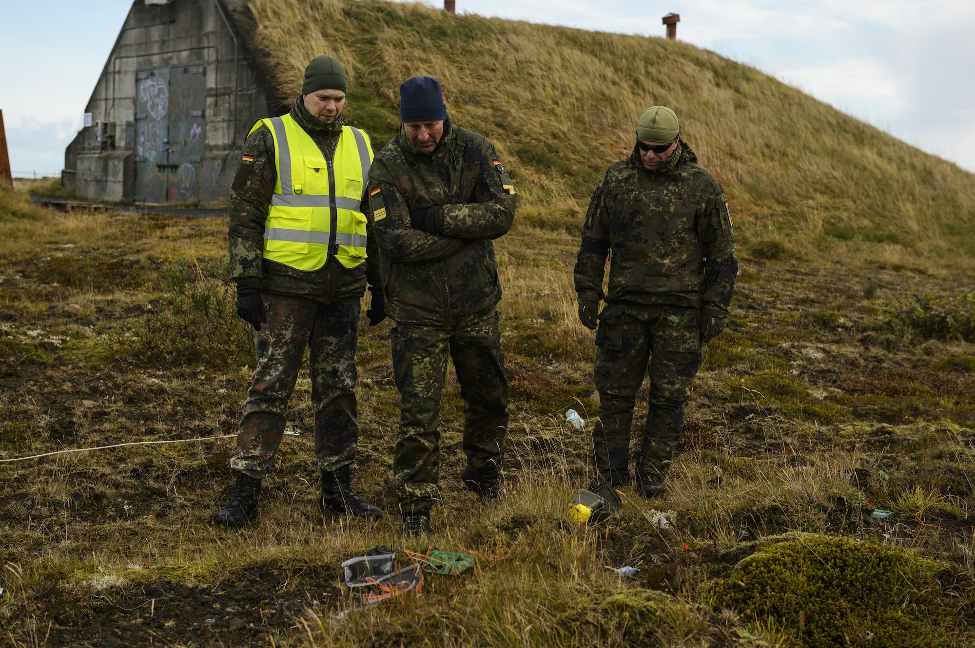 German military observers look at the remaining components of a detonated improvised explosive device during the Northern Challenge 16 exercise at Icelandic Coast Guard Keflavik Facility, Iceland, Sept. 19, 2016. During the exercise, 52nd EOD Airmen worked side by side with counterparts from allied and partner nations to become familiar with each other's military procedures and achieve greater interoperability in combating terrorism. (U.S. Air Force photo by Staff Sgt. Jonathan Snyder)                                                                                                                                                                                    