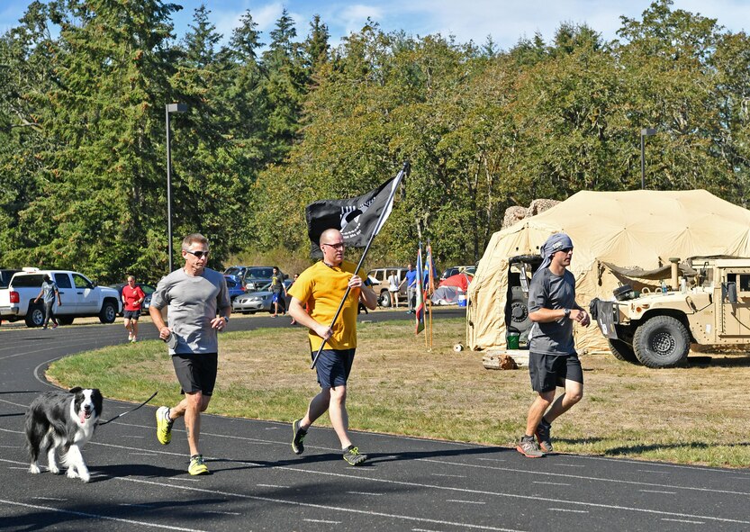 Capt. Joseph Hale, middle, and Bruce Robie, left, from the Western Air Defense Sector run in the POW/MIA Remembrance 24 Hour Run on Joint Base Lewis-McChord Sept. 14 to 15.  The event was hosted by the Air Force Sergeants Association and included participants from 24 Air Force teams from the active duty, Guard, and Reserves assigned to JBLM.  The WADS team members logged 1,037 laps for a total of 259 miles to raise awareness of the missing or imprisoned military service members. (U.S. Air National Guard photo by Kimberly D. Burke)