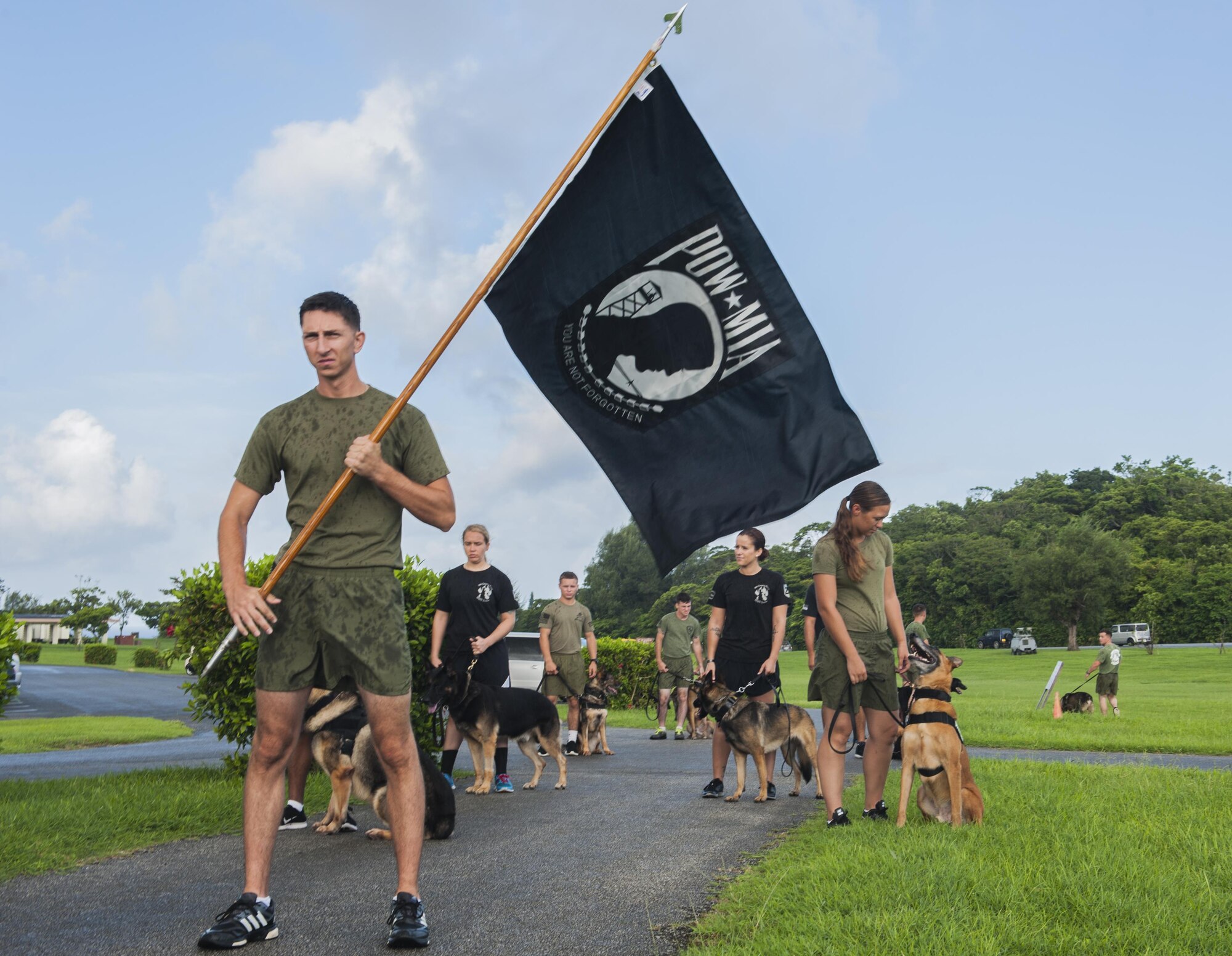 U.S. military members and military working dogs ran the first block of the 24-hour POW/MIA remembrance run, Sept. 15, 2016 at Marek Park on Kadena Air Base, Japan. The POW/MIA flag was originally designed in 1972 by Newt Heisley for the National League of Families. In August 1990, the flag became officially recognized by the United States government. (U.S. Air Force Photo by Airman 1st Class Nick Emerick)  