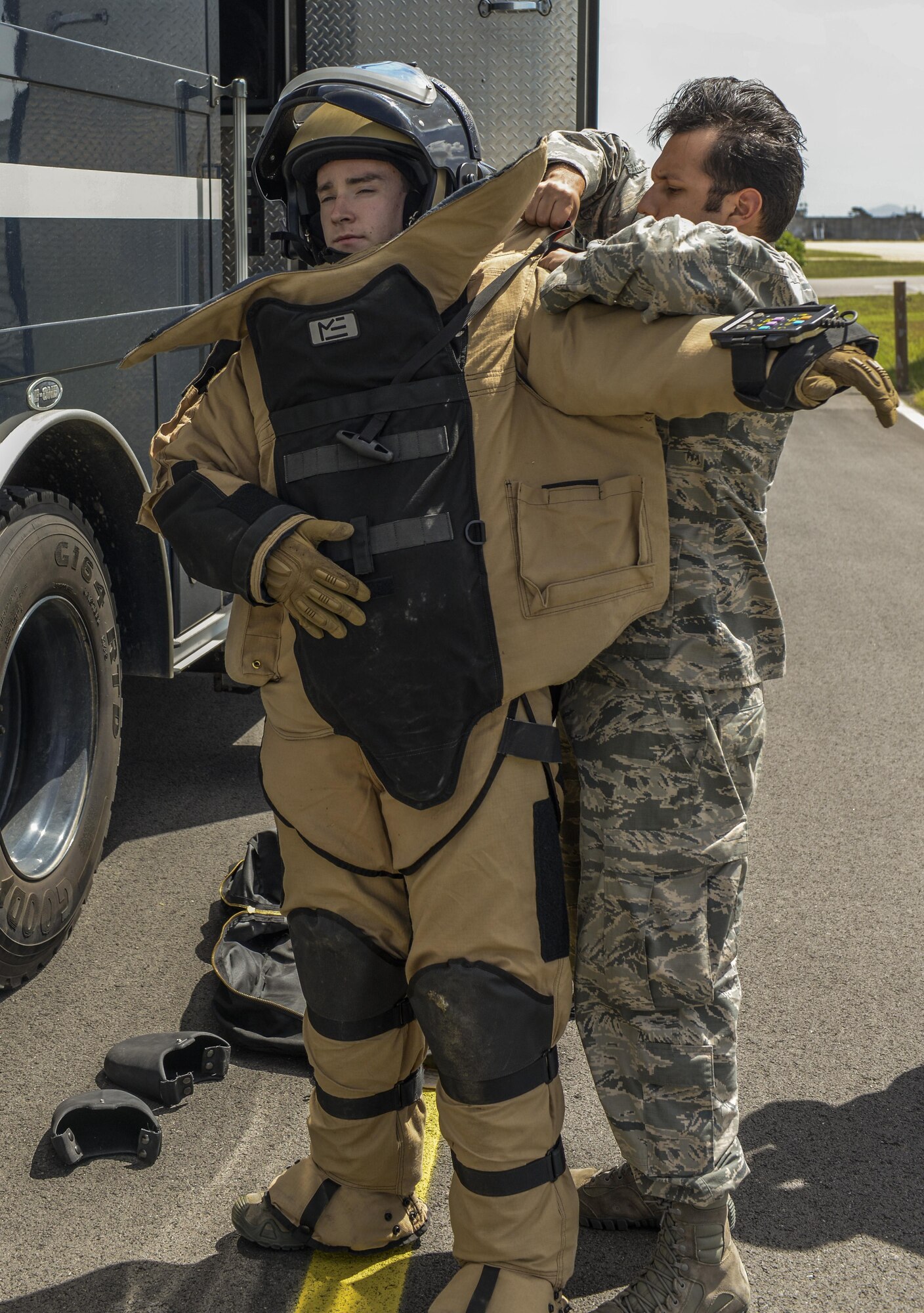 Senior Airman Larry Sanchez, 8th Civil Engineer Squadron Explosive Ordnance Disposal technician, helps Staff Sgt. Shawn Hewitt, 8th CES EOD technician, put on a bomb suit during a training exercise at Kunsan Air Base, Republic of Korea, Aug. 30, 2016. The bomb suit contains heavy body armor made to stand the pressure caused by a bomb and any debris it produces. The suit is made to overlap all parts of the body for full protection.  (U.S. Air Force photo by Senior Airman Colville McFee/Released)