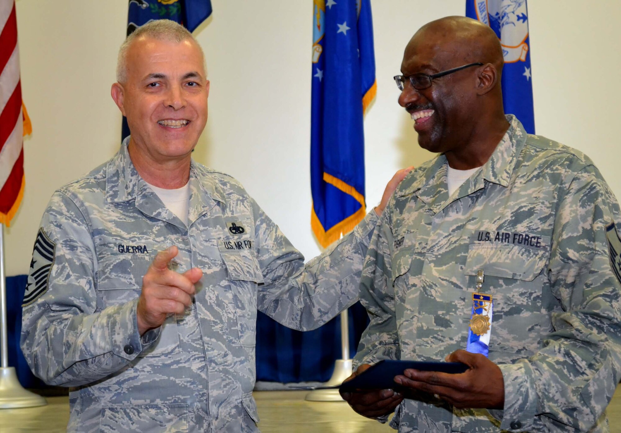 Pa. Air National Guard Command Chief Victor Guerra, of the 171st Air Refueling Wing, Coraopolis, Pa., congratulates Master Sgt. Sylvester Fisher, the 111th Attack Wing student flight monitor, on being awarded the Pennsylvania Gen. William Moffat-Reilly Medal during a ceremony in the Wing headquarters building at Horsham Air Guard Station, Pa., Sept. 10, 2016. The medal is awarded to the service member with the longest continuous service in the Pa. National Guard – Army or Air Force. (U.S. Air Force photo by Tech. Sgt. Andria Allmond)