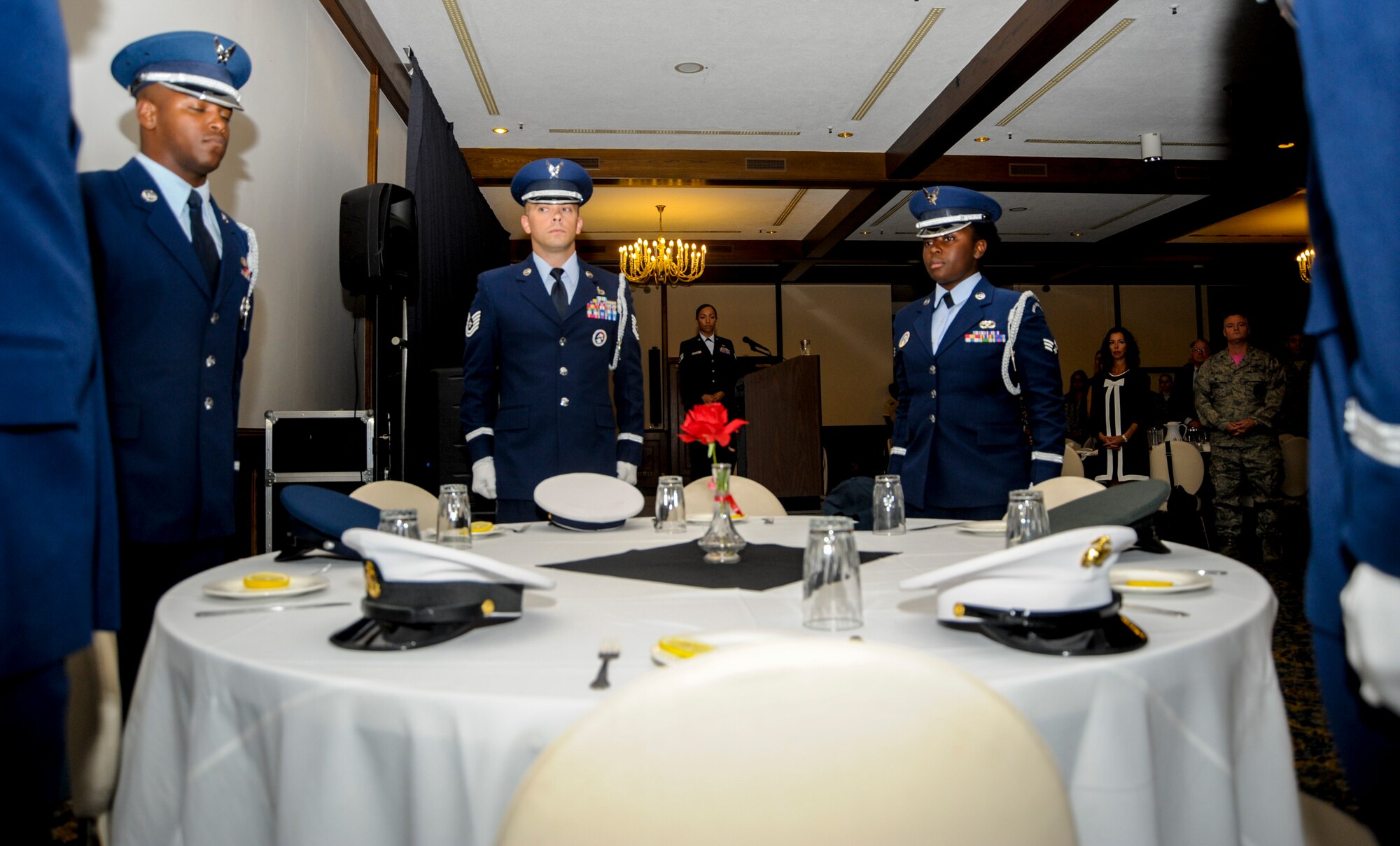 Members of the Ramstein Air Base Honor Guard place service caps on a table reserved for past and present U.S. service members and civilians listed as prisoners of war and missing in action during the POW/MIA Recognition Day ceremony Sept. 16, 2016, at Ramstein Air Base, Germany. Six service caps were placed on the table as representation of the U.S. Air Force, Army, Navy, Marines, Coast Guard and civilians. (U.S. Air Force photo/Staff Sgt. Timothy Moore)