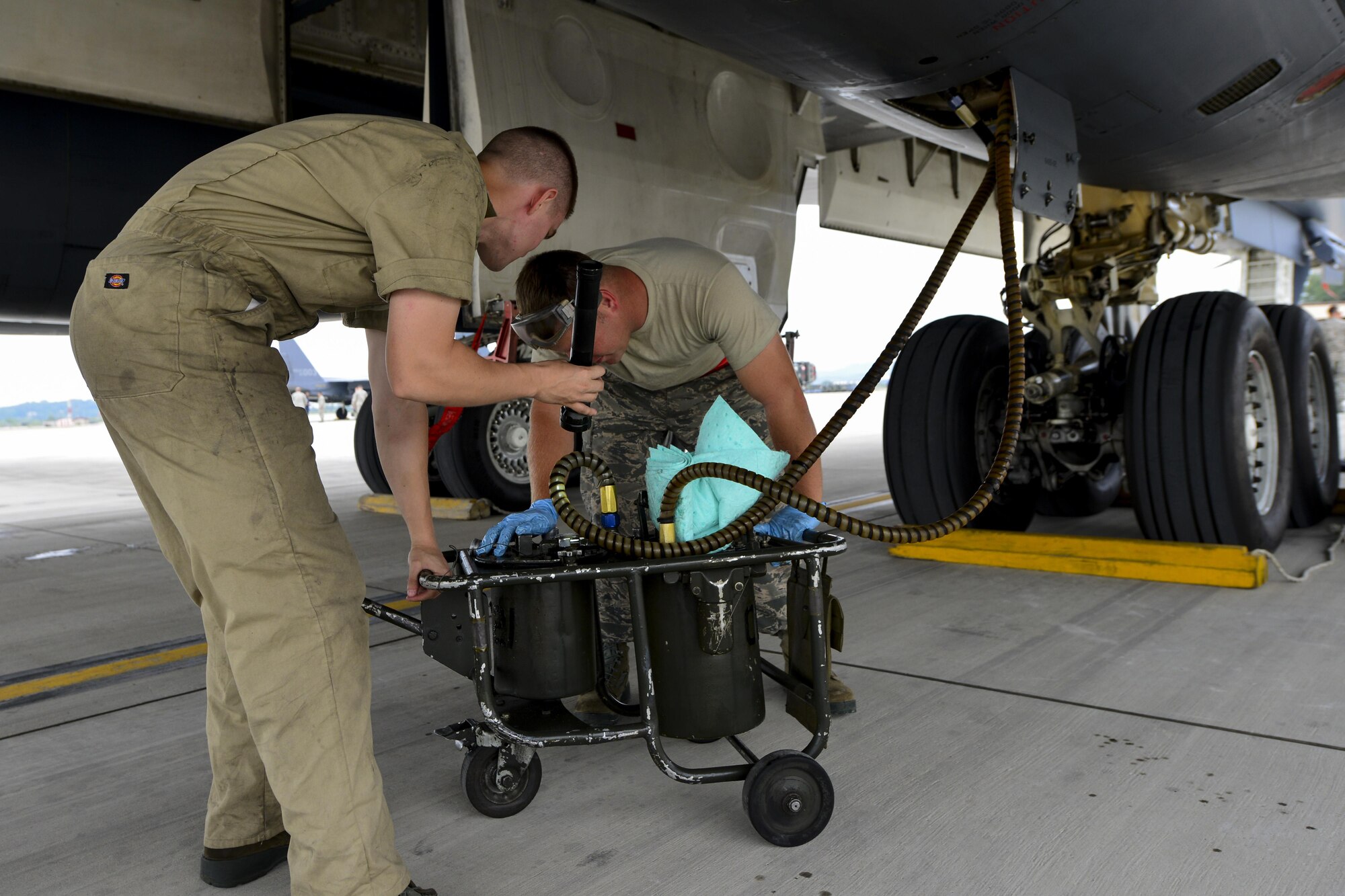 Two maintenance Airmen from the 34th Expeditionary Aircraft Maintenance Unit at Anderson Air Base, Guam, check hydraulic fluid during a post-flight inspection on a B-1B Lancer at Osan Air Base, Republic of Korea, Sept. 21, 2016. The B-1 had just conducted its closest flight to the North Korean border ever and is the first to land on the Korean Peninsula since 1996. (U.S. Air Force photo by Senior Airman Victor J. Caputo)