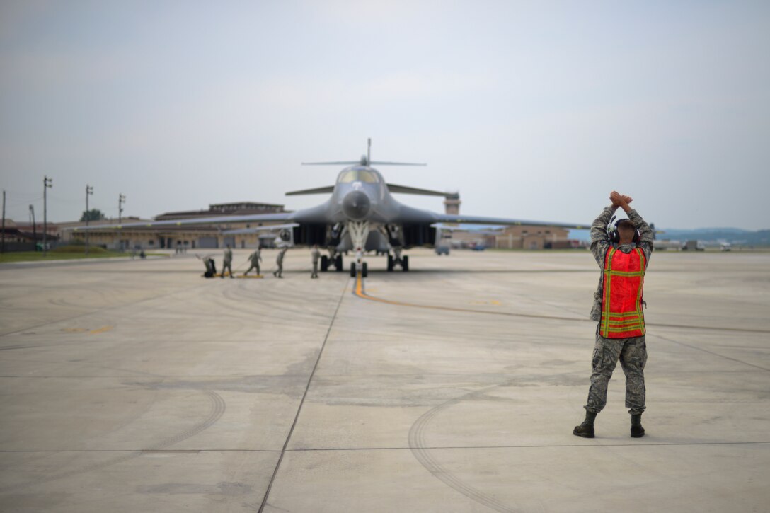 U.S. Air Force Staff Sgt. Justin Shields, 34th Expeditionary Aircraft Maintenance Unit crew chief, marshals a B-1B Lancer into a parking spot at Osan Air Base, Republic of Korea, Sept. 21, 2016. The B-1 had just conducted its closest flight to the North Korean border ever, as well as landing on the Korean Peninsula for the first time since 1996. The B-1 is deployed from Andersen Air Base, Guam. (U.S. Air Force photo by Senior Airman Victor J. Caputo)