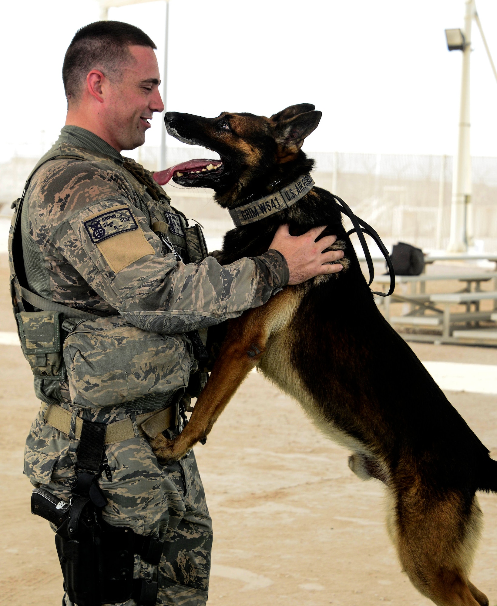 Staff Sgt. Jacob Brown, 379th Expeditionary Security Forces Squadron military working dog handler, plays with his dog, Grim, after completing a training scenario Sept. 16, 2016, at Al Udeid Air Base, Qatar. MWDs and their handlers work throughout the region to support detection and deterrence efforts. (U.S. Air Force photo/Senior Airman Janelle Patiño/Released)