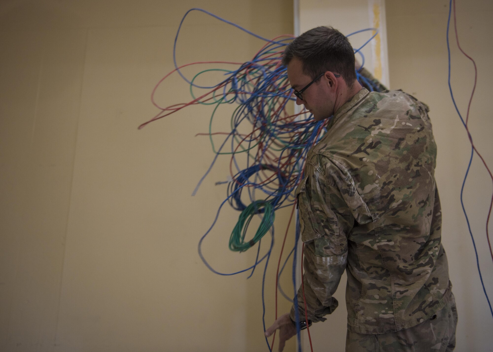 Senior Airman John Roach, 455th Expeditionary Communications Squadron, cable and antenna maintenance journeyman, gathers old cables together, Bagram Airfield, Afghanistan, Sept. 20, 2016. The cable team ensures that all cable and wireless systems are installed and maintained and provide command and control (C2) capabilities throughout the base. (U.S. Air Force photo by Senior Airman Justyn M. Freeman)