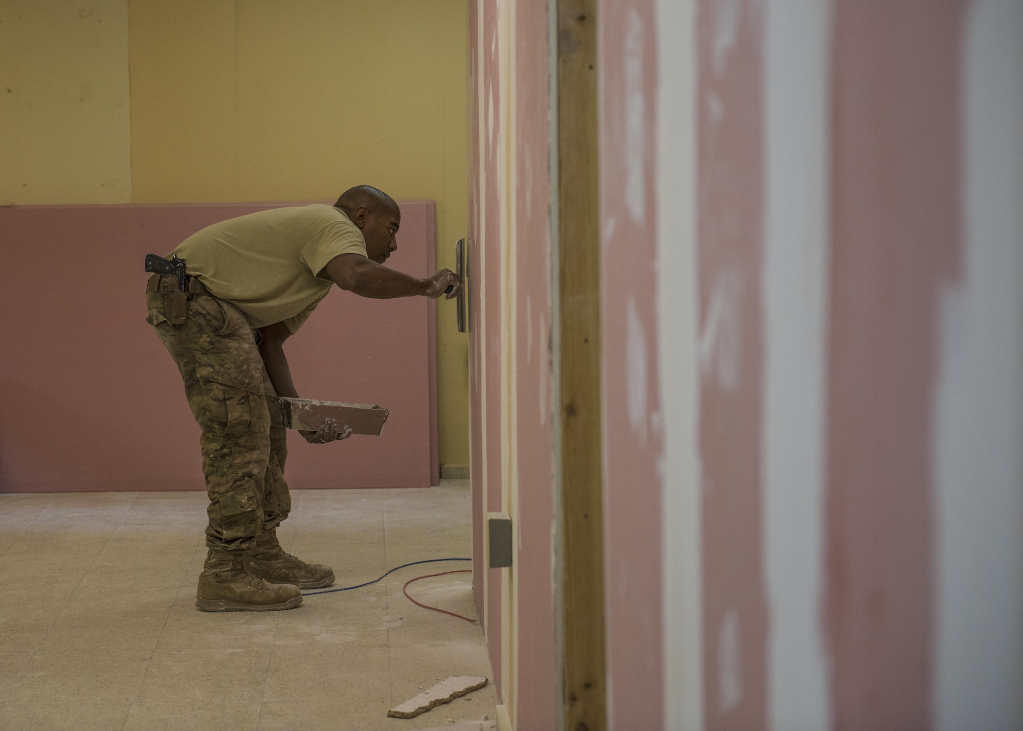 Staff Sgt. Donald Scott, 455th Expeditionary Civil Engineer Squadron structures, applies joint compound which helps seal joints between drywall, Bagram Airfield, Afghanistan, Sept. 20, 2016. The structures team paired with the 455th ECS to renovate and provide communications for the building. (U.S. Air Force photo by Senior Airman Justyn M. Freeman)