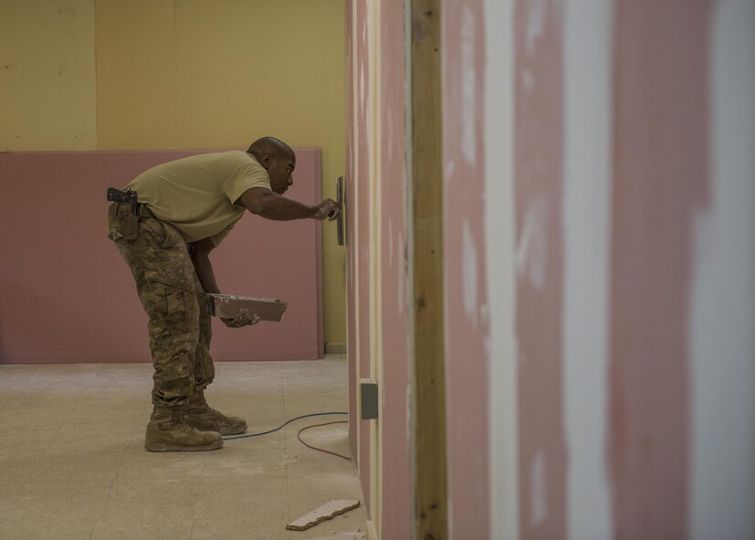 Staff Sgt. Donald Scott, 455th Expeditionary Civil Engineer Squadron structures, applies joint compound which helps seal joints between drywall, Bagram Airfield, Afghanistan, Sept. 20, 2016. The structures team paired with the 455th ECS to renovate and provide communications for the building. (U.S. Air Force photo by Senior Airman Justyn M. Freeman)