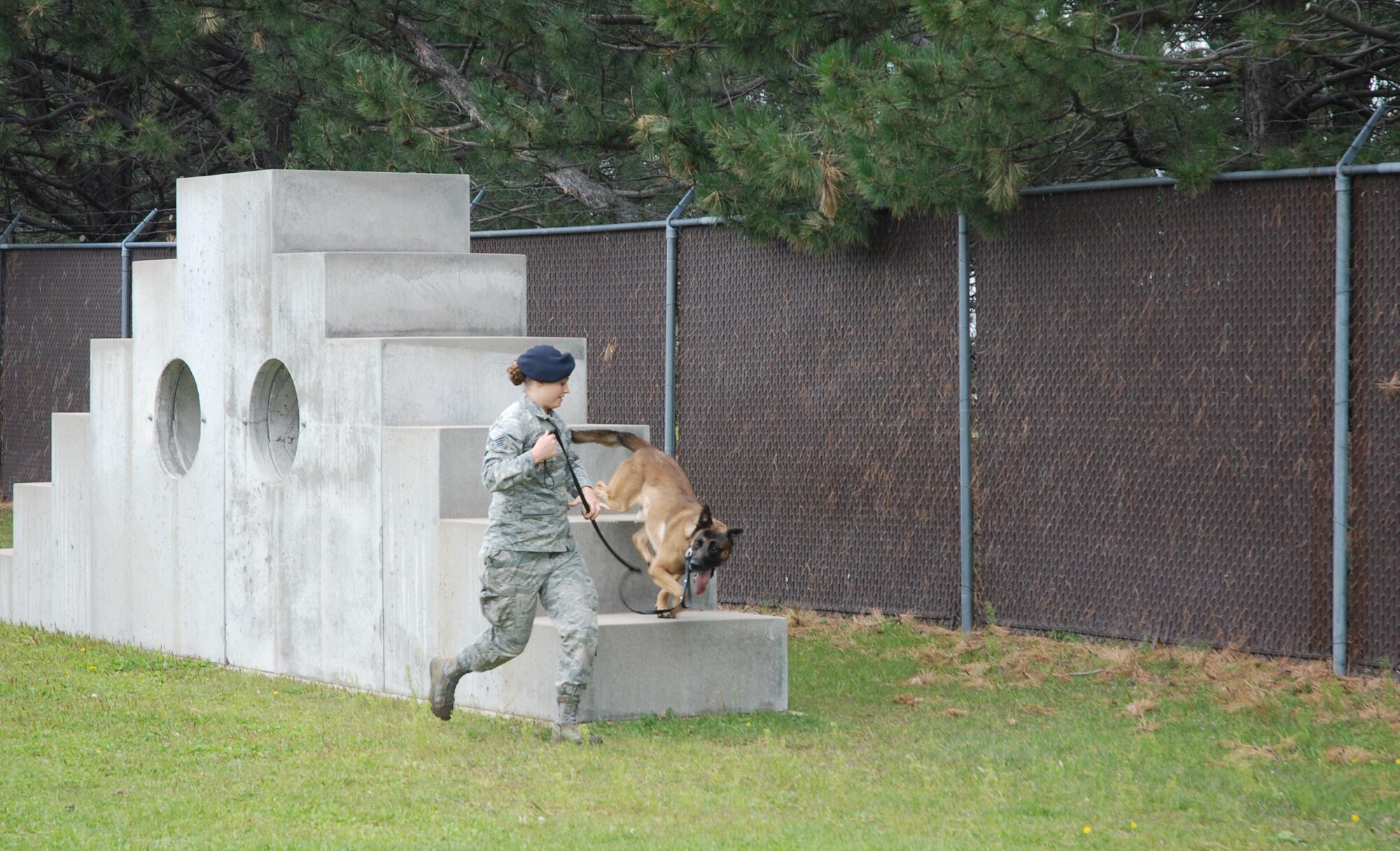 PETERSON AIR FORCE BASE, Colo. – Senior Airman Amanda Legault, 21st Security Forces Squadron military working dog handler, runs the obstacle course with her K-9 partner, Dano, at the kennels on Peterson Air Force Base, Colo., Sept. 1, 2016. Legault completed an obstacle course and bite training session with Dano.  (U.S. Air Force photo by Dave Smith)