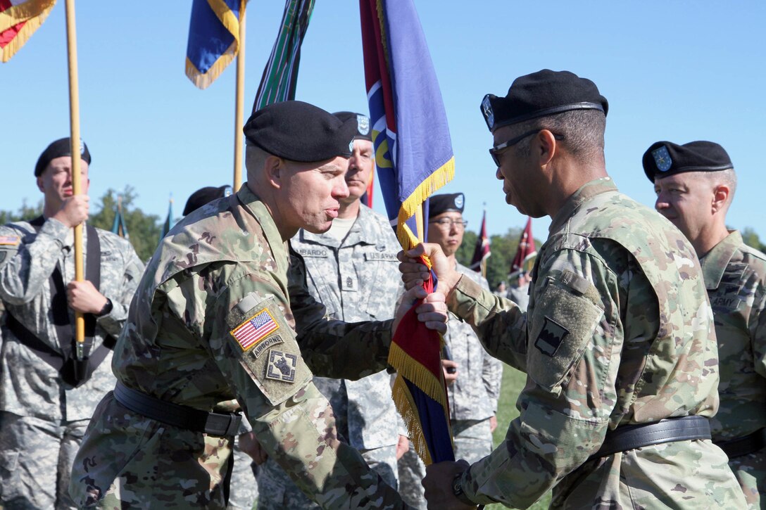 Brig. Gen. Aaron T. Walter, incoming commander of the 100th Training Division Operations Support, accepts the division’s colors from the Commanding General of the 80th Training Command (TASS), Maj. Gen. A.C. Roper, during a change of command ceremony at Brooks Parade Field Fort Knox, Ky., Sept. 11, 2016.