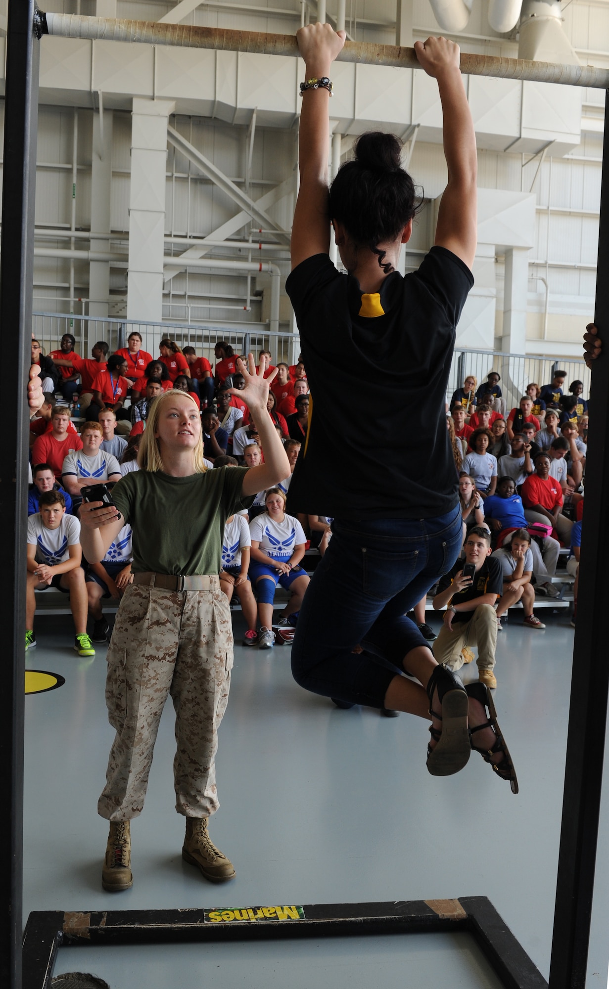 U.S. Marine Lance Cpl. Sarah Tedford, Keesler Marine Detachment student, shows Elizabeth Zelaya, D’Iberville High School Junior ROTC student, her remaining time to hang on the pull-up bar during a pull-up competition at the Science, Technology, Engineering and Mathematics Diversity Outreach Day in the fuel cell hangar Sept. 16, 2016 on Keesler Air Force Base, Miss. The event also consisted of nine Mississippi gulf coast high school Junior ROTC units and science students viewing an 81st Security Forces Squadron military working dog demonstration and visiting informative booths about Air Force opportunities and accession requirements with an emphasis on STEM. (U.S. Air Force photo by Kemberly Groue/Released)