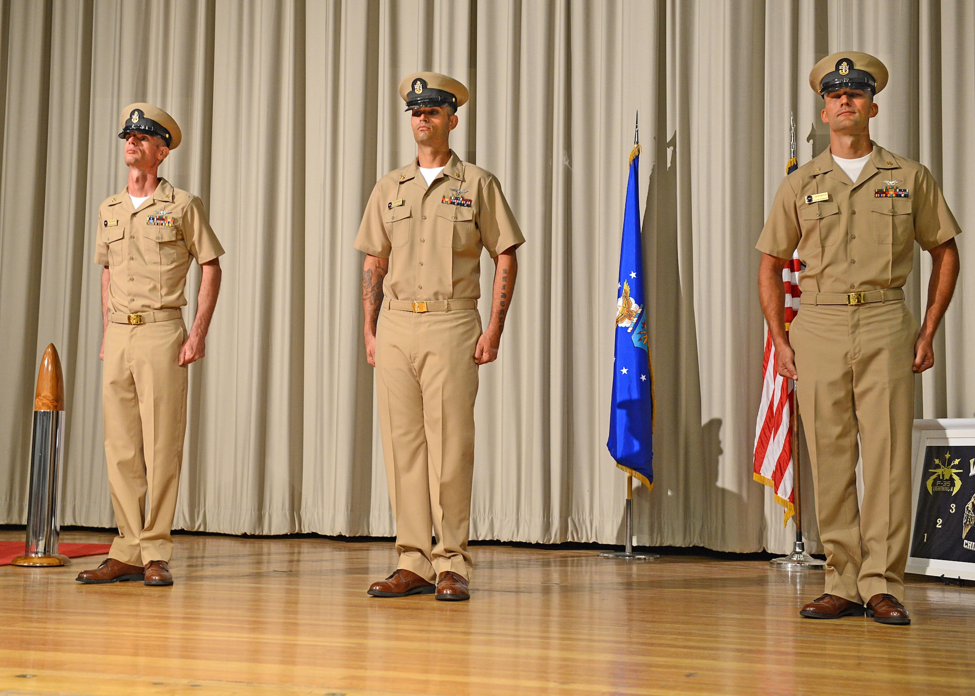 From left to right: Chief Petty Officers Richard Crapser, Lawrence Borba and Justin Sexton don their new khaki uniforms and CPO combination covers after pinning on their anchors to officially become U.S. Navy CPOs at the base theater Sept. 16. Almost 5,000 Sailors across the Navy pinned on the rank of CPO last Friday. (U.S. Air Force photo by Kenji Thuloweit)