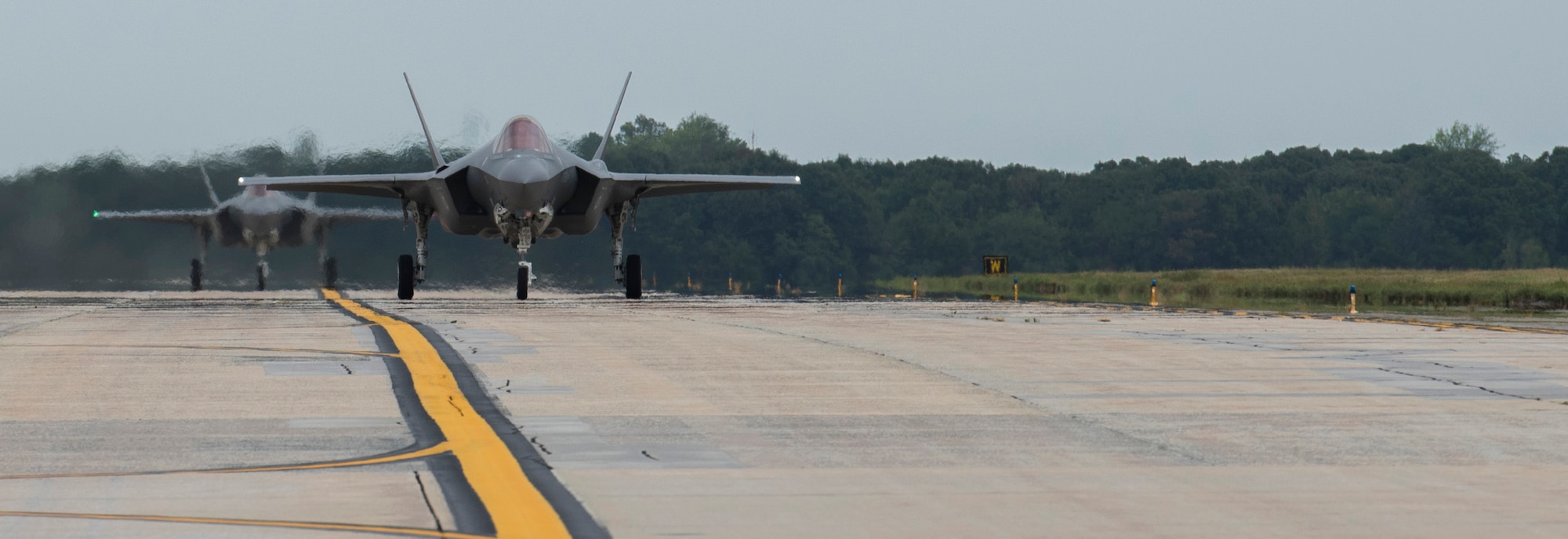 Two F-35 Lightning II aircraft taxi down the flight line at Joint Base Andrews, Md., Sept. 20, 2016. The aircraft are here to perform a fly-over during the U.S. Air Force Tattoo at Joint Base Anacostia-Bolling, D.C., Sept. 22, 2016. (U.S. Air Force photo by Airman Gabrielle Spalding)