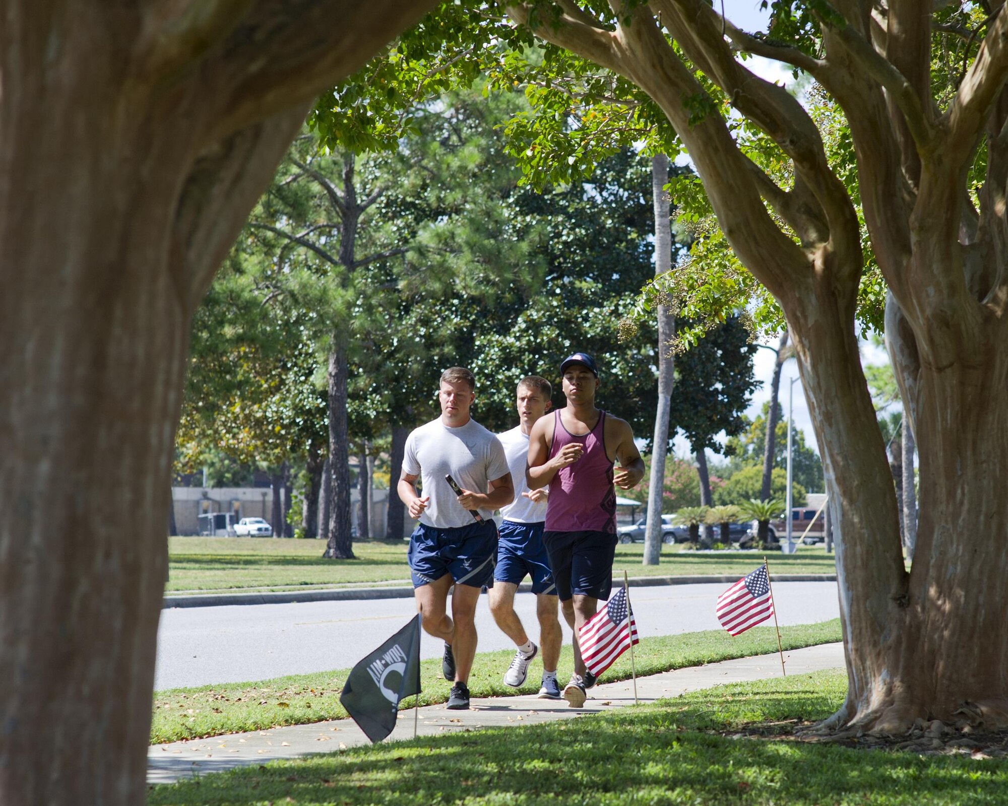(Left to right) U.S. Air Force Staff Sgt. Matt Ballad, 325th Operations Support Squadron aircrew flight equipment craftsman, Airman 1st Class Shane Simosko, 337th Air Control Squadron weapons simulation technician, and Airman 1st Class Frank Stanford, 325th OSS AFE journeyman, participate in the Prisoner of War/Missing in Action Memorial 24 Hour Vigil Run at Flag Park, Tyndall Air Force Base, Fla., Sept. 15, 2016. During the event, at least one participant ran with the ceremonial baton at all times. (U.S. Air Force photo by Staff Sgt. Alex Fox Echols III/Released)