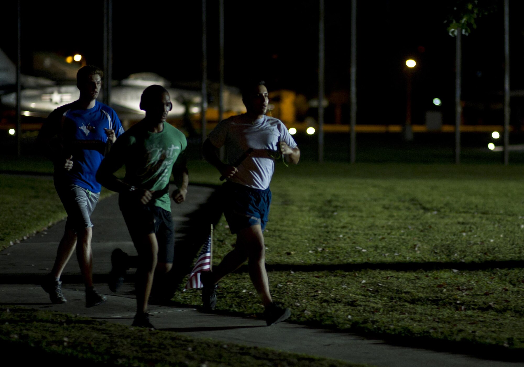 (Left to right) U.S. Air Force Senior Airmen Dustin Mullen and Ty-Rico Lea, and Tech. Sgt. Javier Cruz from the 325th Fighter Wing Public Affairs Office participate in the Prisoner of War/Missing in Action Memorial 24 Hour Vigil Run at Flag Park, Tyndall Air Force Base, Fla., Sept. 16, 2016. The public affairs team ran for two hours, from midnight to 2 a.m., during the memorial event. (U.S. Air Force photo by Staff Sgt. Alex Fox Echols III/Released)