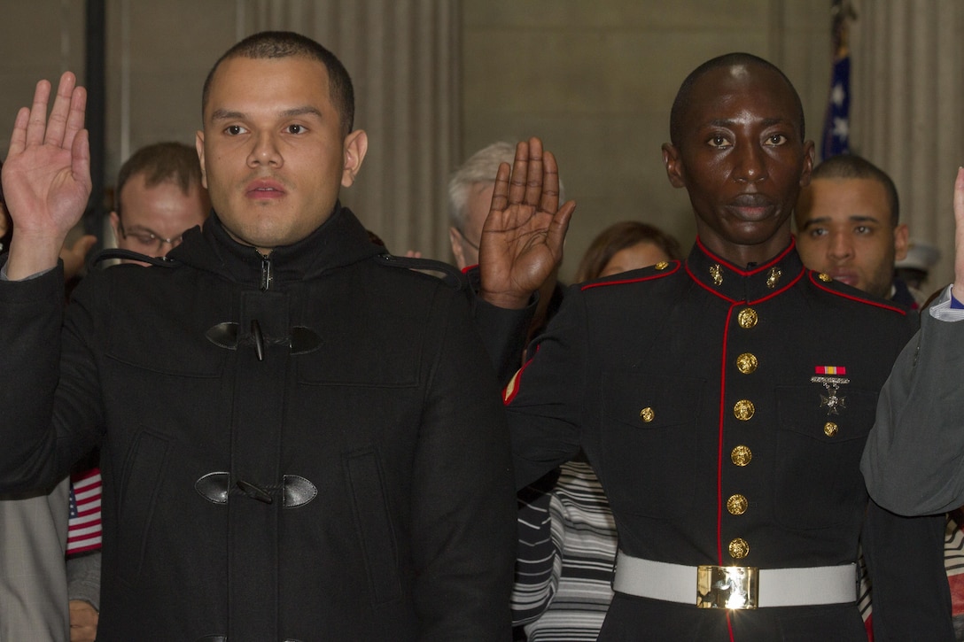 Retired Lance Cpl. Alex R. Arteaga, a former MV-22 Osprey mechanic with Marine Medium Tiltrotor Squadron 263, and Lance Cpl. Torffic Hassan, a Reserve Marine with 6th Communications Battalion, take the Naturalization Oath of Allegiance March 22, 2013, during a Naturalization Ceremony at the Federal Hall National Memorial. Arteaga came to the United States from the Republic of Ecuador in 2005 and Hassan immigrated in 2009 from the Republic of Ghana, West Africa. (U.S. Marine Corps photo by Cpl. Juan D. Alfonso)