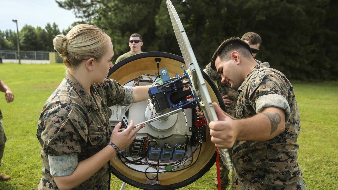 Marines check for electrical issues inside a Meteorological Radar Subsystem at Marine Corps Air Station New River, N.C., Sept. 14, 2016. Marines with Meteorology and Oceanography platoon, 2nd Intelligence Battalion and Marine Air Traffic Control Detachment Bravo, Marine Air Traffic Control Squadron 2 ensure the wiring is correct before operating the MRS.