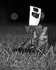 Combat boots line the outdoor track in the rain at Minot Air Force Base, N.D., Sept. 15, 2016. The boots symbolized prisoners of war and missing in action service members during a POW/MIA memorial event. (Airman 1st Class J.T. Armstrong)