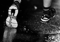 An Airman’s shoes splash through the puddles around the outdoor track at Minot Air Force Base, N.D., Sept. 15, 2016. Airmen from across both wings ran the Prisoners of War/Missing in Action flag around the outdoor track for 24 hours in honor of those who are lost but not forgotten. (Airman 1st Class J.T. Armstrong)