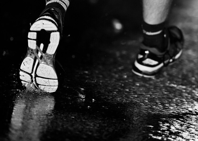 An Airman’s shoes splash through the puddles around the outdoor track at Minot Air Force Base, N.D., Sept. 15, 2016. Airmen from across both wings ran the Prisoners of War/Missing in Action flag around the outdoor track for 24 hours in honor of those who are lost but not forgotten. (Airman 1st Class J.T. Armstrong)