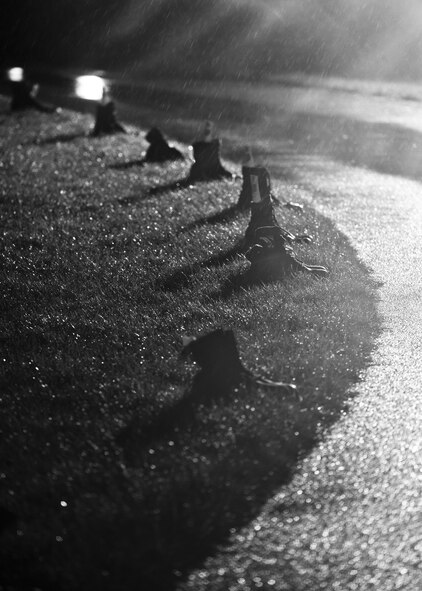 Combat boots line the outdoor track in the rain at Minot Air Force Base, N.D., Sept. 15, 2016. The boots symbolized prisoners of war and missing in action service members during a POW/MIA memorial event. (Airman 1st Class J.T. Armstrong)