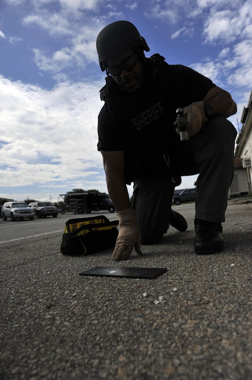 Detective Carl Makins, a hazardous device technician with the Charleston County Sheriff's Office, examines a powder sample from an exploded ordnance during a training exercise here, Sept. 21, 2016. The local bomb squads often train with members from the 628th Civil Engineer Squadron's Explosive Ordnance Disposal flight to build relationships and streamline operating procedures between state and federal entities.