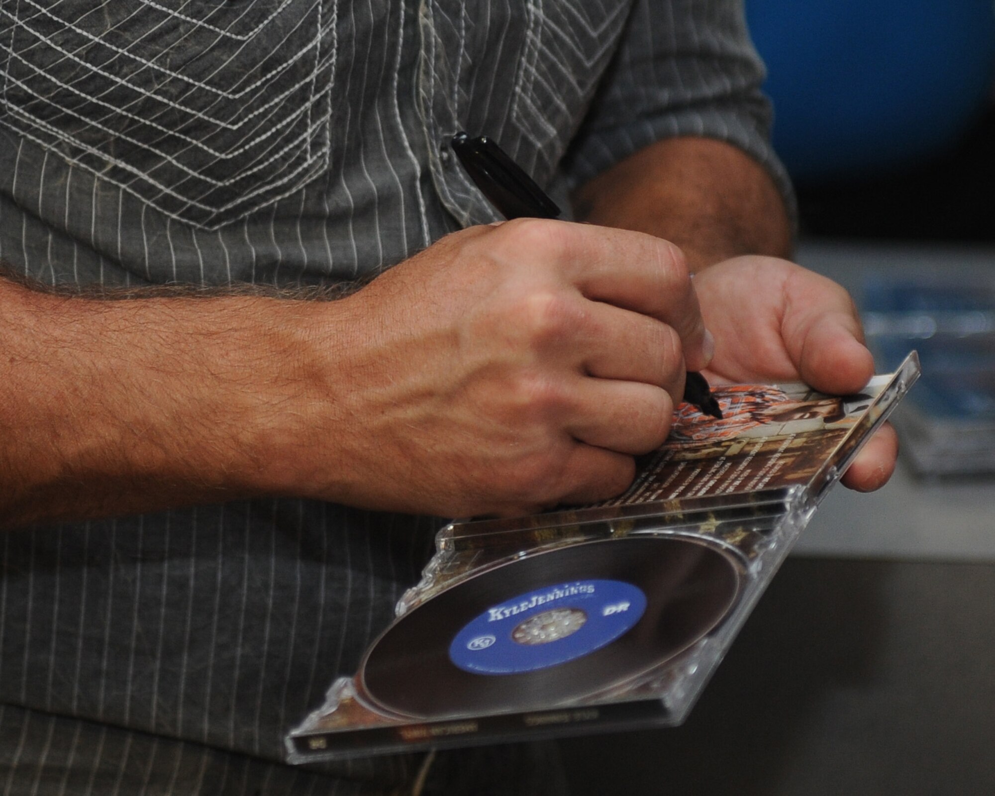 Kyle Jennings, a country music artist, signs a CD for an Airman after the concert at Barksdale Air Force Base, La., Sept. 16, 2016. In addition to signing memorabilia, Jennings also posed for photos with the fans after the concert. (U.S. Air Force photo/Airman 1st Class Stuart Bright)