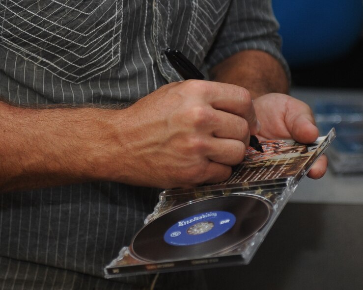Kyle Jennings, a country music artist, signs a CD for an Airman after the concert at Barksdale Air Force Base, La., Sept. 16, 2016. In addition to signing memorabilia, Jennings also posed for photos with the fans after the concert. (U.S. Air Force photo/Airman 1st Class Stuart Bright)