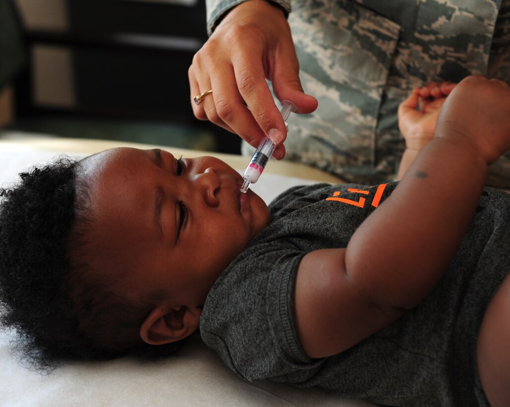 U.S. Air Force Staff Sgt. Hilary Tenebruso, 7th Medical Operations Squadron immunization technician, applies an oral vaccine to a child at Dyess Air Force Base, Texas, Aug. 31, 2016. Vaccines given by the immunizations flight range from influenza to smallpox. (U.S. Air Force photo by Airman 1st Class April Lancto)