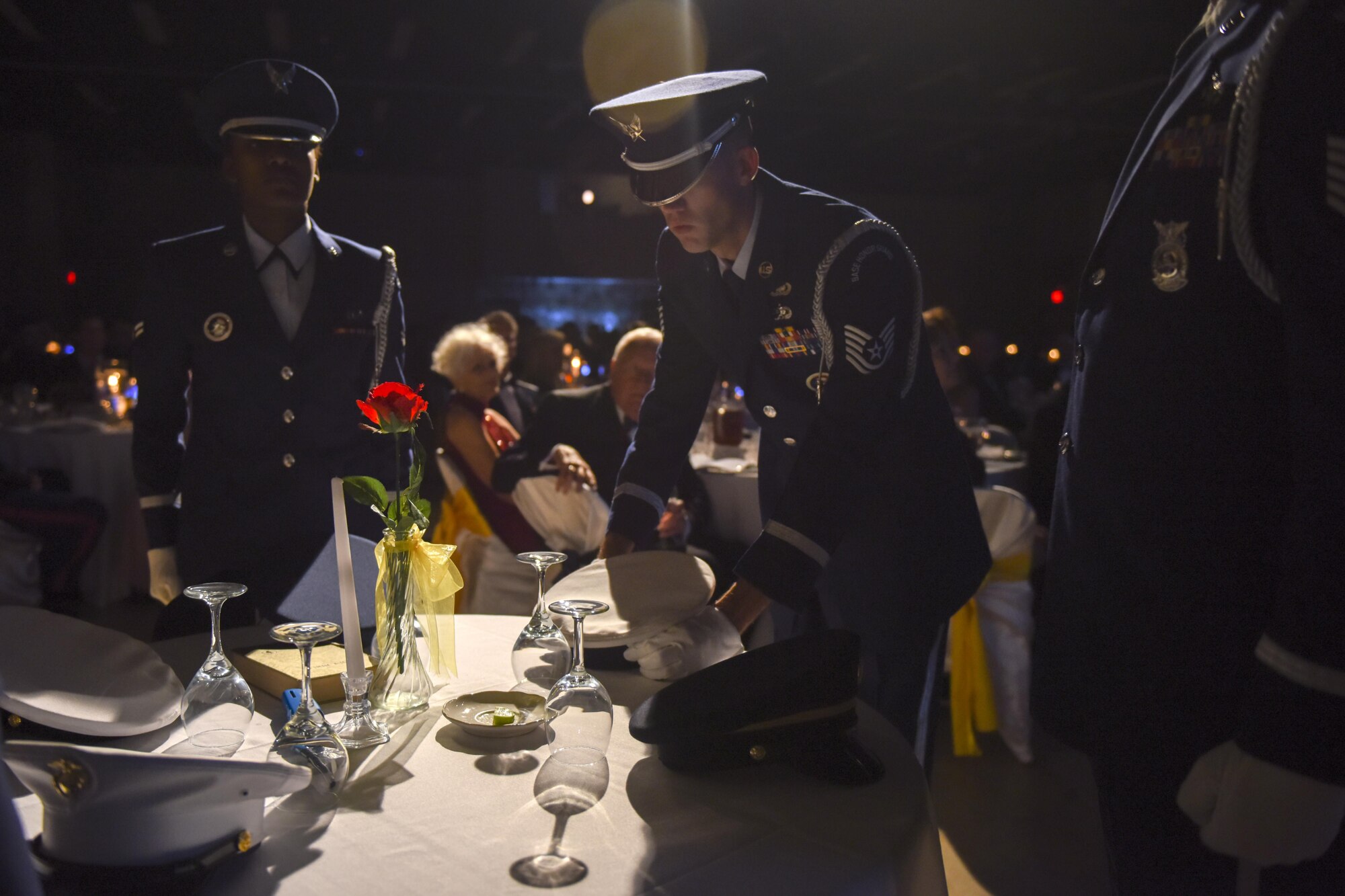 U.S. Air Force Tech. Sgt. James Pennington, Goodfellow Air Force Base Honor Guard NCO in charge, places a service cap on a POW/MIA table during Goodfellow Air Force Base’s Annual Air Force Ball at the McNease Convention Center, San Angelo, Texas, Sept. 16, 2016. The POW/MIA table honored missing and captured service members. (U.S. Air Force photo by Airman 1st Class Chase Sousa/Released) 
