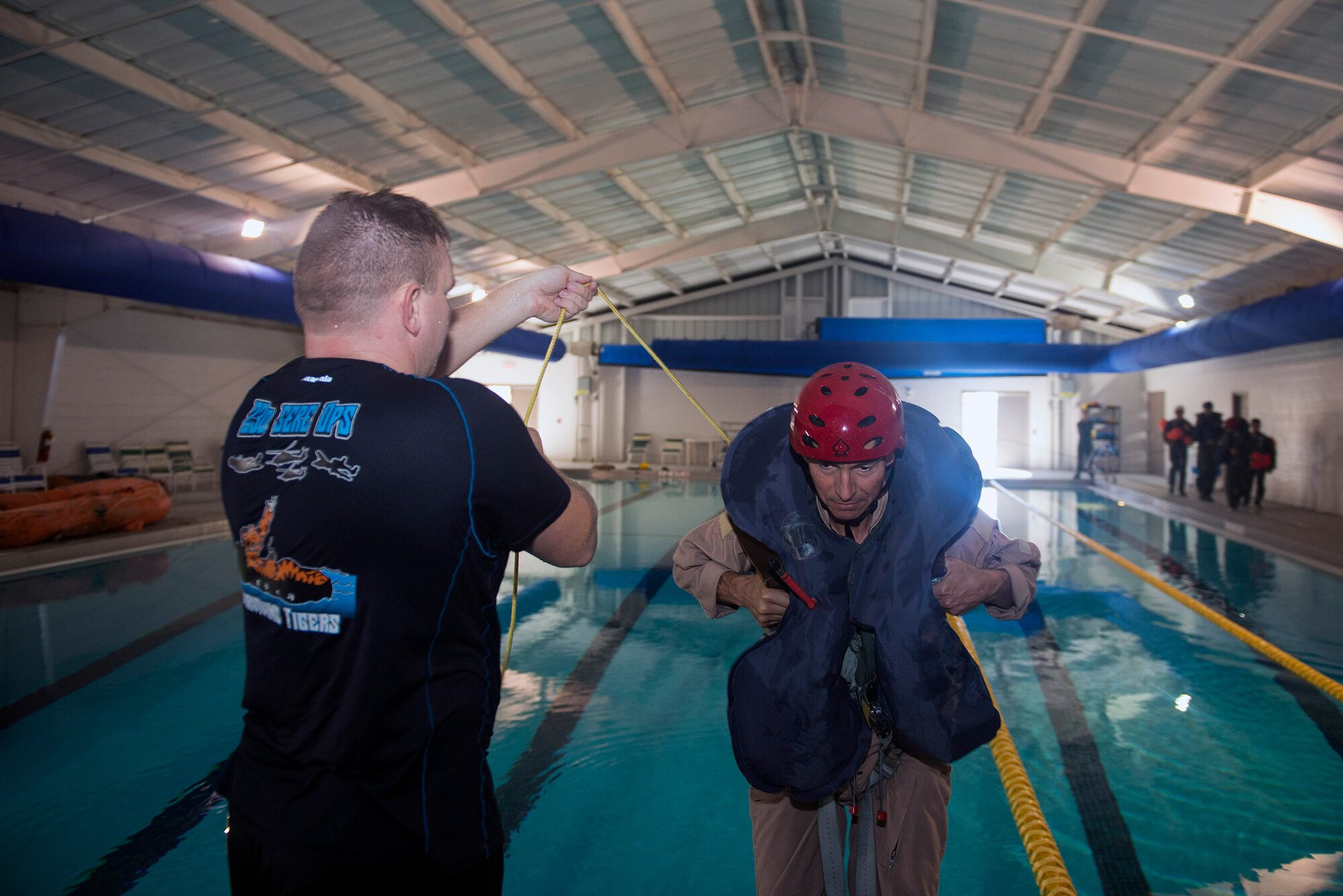 U.S. Air Force Tech. Sgt. Travis Siegwart, 347th Operations Support Squadron NCO in charge of survival, evasion, resistance and escape training, prepares to release Mark Mouw, 81st Fighter Squadron A-29 Super Tucano civilian pilot, during a parachute unharnessing scenario during water survival training, Sept. 15, 2016, at Moody Air Force Base, Ga. This scenario teaches aircrew members proper techniques to safely disconnect their parachutes while experiencing high winds. (U.S. Air Force photo by Airman 1st Class Greg Nash)