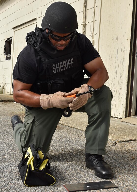 Detective Carl Makins, a hazardous device technician with the Charleston County Sheriff's Office, examines a powder sample from an exploded ordnance during a training exercise here, Sept. 21, 2016. The local bomb squads often train with members from the 628th Civil Engineer Squadron's Explosive Ordnance Disposal flight to build relationships and streamline operating procedures between state and federal entities.