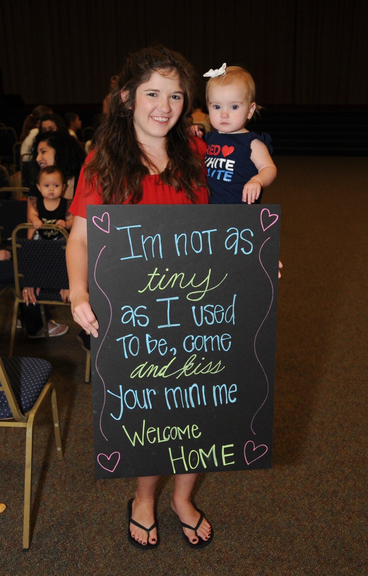 A mother waits with her daughter for her father to return home at Barksdale Air Force Base, La., Sept. 19, 2016. Barksdale Airmen were deployed to Al Udeid Air Base, Qatar, in support of Operation Inherent Resolve. (U.S. Air Force photo/Airman Alexis C. Schultz)