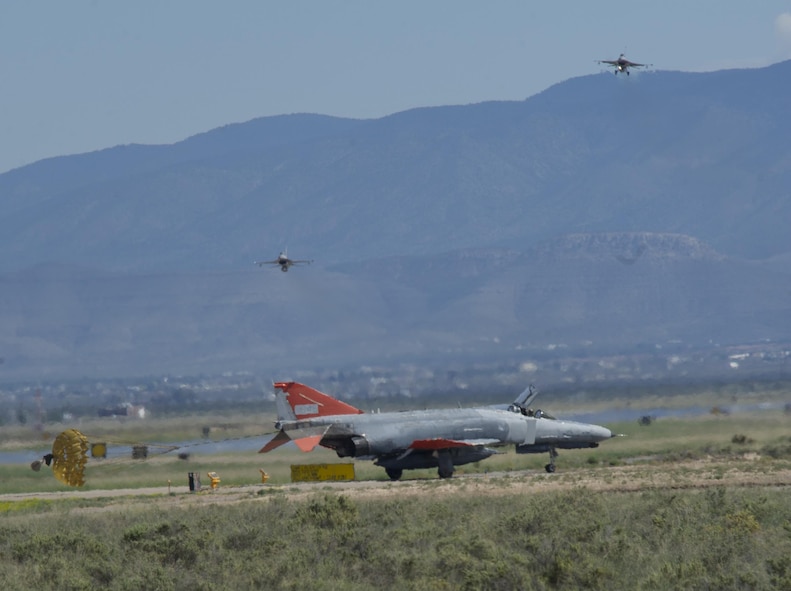 A QF-4 Phantom II taxis after arrival to Holloman Air Force Base, N.M., on Sept. 13, 2016, while two F-16 Fighting Falcons depart in front of 160 spectators participating in Holloman’s annual Phantom Society Tour. The tour enabled aircraft enthusiasts, including veterans and non-veterans with aviation backgrounds, to explore various base locations. The tour also included an F-16 Fighting Falcon static display and briefing, travel to Holloman’s High Speed Test Track, the opportunity to view QF-4 Phantom IIs and F-16s in flight, and a visit to the base’s heritage park to view static displays of various aircraft historically stationed at Holloman AFB. (U.S. Air Force photo by Master Sgt. Matthew McGovern)