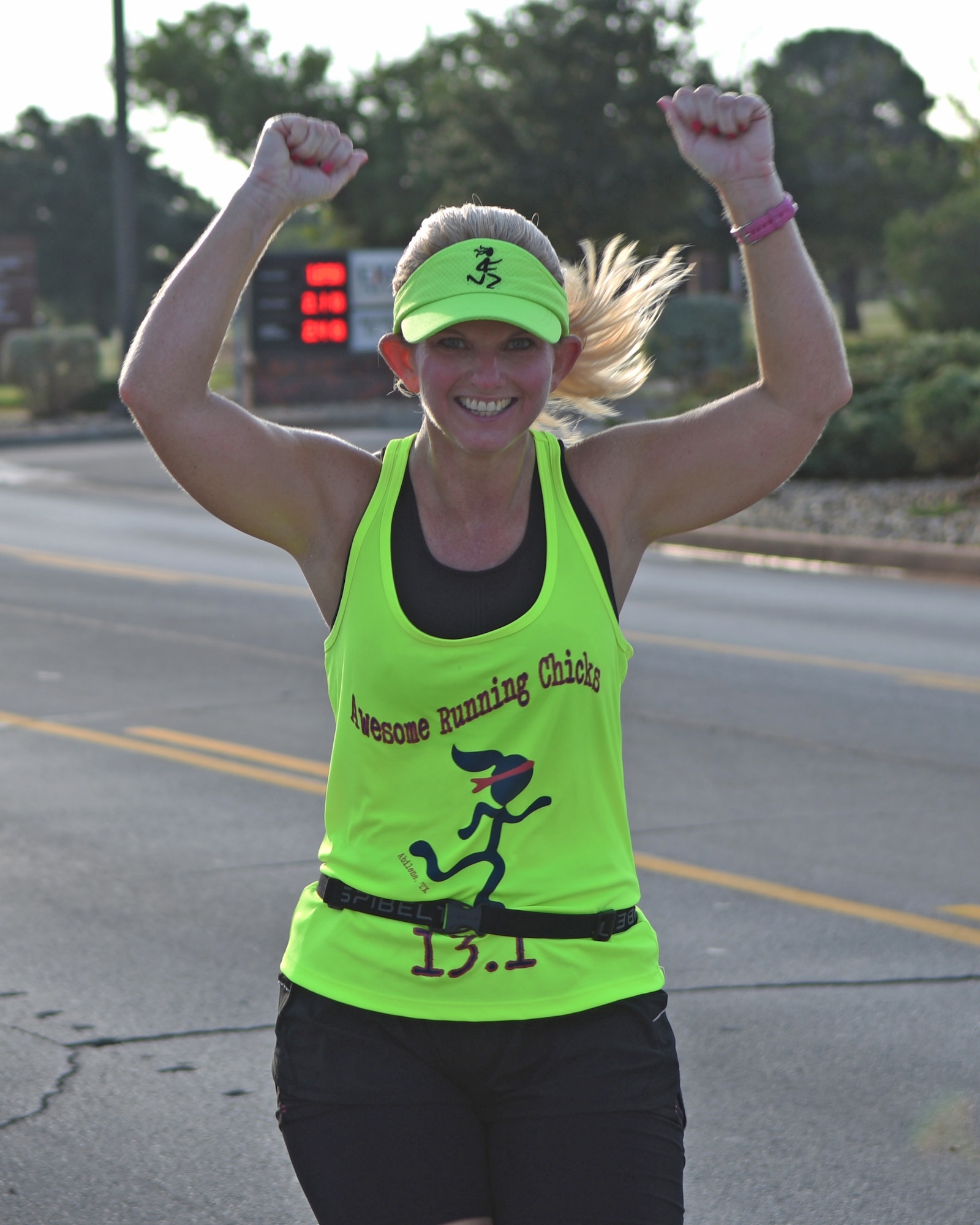 Tera Gibson, Hardin-Simmons University human resources director, raises her hands after finishing the 10K during the Dyess Mini Marathon, at Dyess Air Force Base, Texas, Sept. 17, 2016. The Dyess Fitness Center hosted the event on the same day as the Air Force Marathon in Wright Patterson AFB, Ohio to commemorate the Air Force's 69th birthday. (U.S. Air Force photo by Senior Airman Kedesha Pennant)

