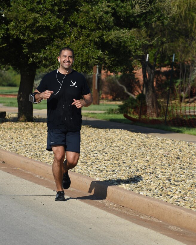 U.S. Air Force Master Sgt. Carlos Caballero, 7th Component Maintenance Squadron central repair facility support chief, smiles as he runs the half marathon during the Dyess Mini Marathon, at Dyess Air Force Base, Texas, Sept. 17, 2016. More than 50 participants across Abilene competed in the 5K, 10K or half marathon to celebrate the Air Force's 69th birthday. (U.S. Air Force photo by Senior Airman Kedesha Pennant)