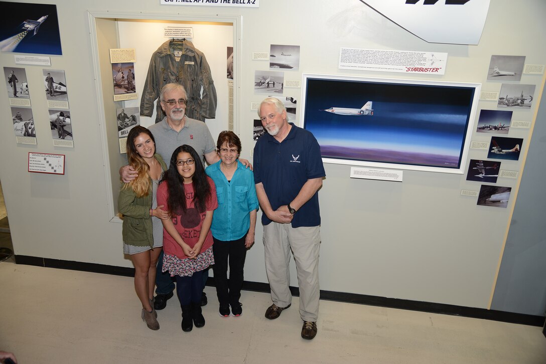 Lorrie Epling (center), daughter of test pilot Milburn G. "Mel" Apt, and her family, daughters Rachel (left) and Brisley and husband Michael, pose with museum specialist Tony Moore in front of the newly-unveiled display of Apt and Bell X-2 at the Air Force Flight Test Museum Sept. 16.  Apt was a US test pilot, and the first man to attain speeds faster than Mach 3. He was killed in the destruction of the Bell X-2 during the record-setting flight that exceeded Mach 3 on September 27, 1956. Moore designed and constructed the X-2 display. (U.S. Air Force photo by Christopher Ball)