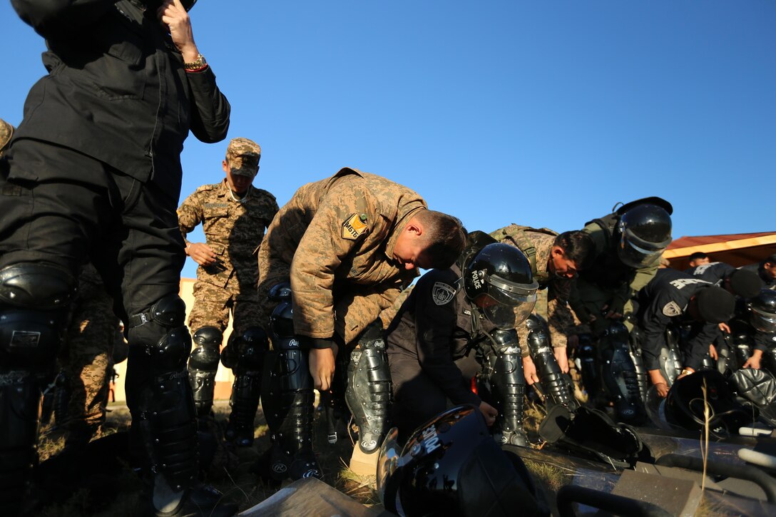 Mongolian Armed Forces soldiers and Mongolian National Police put on protective gear for the final field training exercise demonstration during Non-Lethal Executive Seminar (NOLES) 2016 at Five Hills Training Area, Mongolia, Sept. 21, 2016. Mongolian soldiers and National Police completed the final portion of the field training exercise for NOLES with several rehearsed scenarios. Non-lethal weapons are designed to incapacitate equipment and personnel while minimizing fatalities and permanent injury to personnel, and undesired collateral damage to property. 