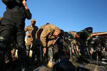 Mongolian Armed Forces soldiers and Mongolian National Police put on protective gear for the final field training exercise demonstration during Non-Lethal Executive Seminar (NOLES) 2016 at Five Hills Training Area, Mongolia, Sept. 21, 2016. Mongolian soldiers and National Police completed the final portion of the field training exercise for NOLES with several rehearsed scenarios. Non-lethal weapons are designed to incapacitate equipment and personnel while minimizing fatalities and permanent injury to personnel, and undesired collateral damage to property. 