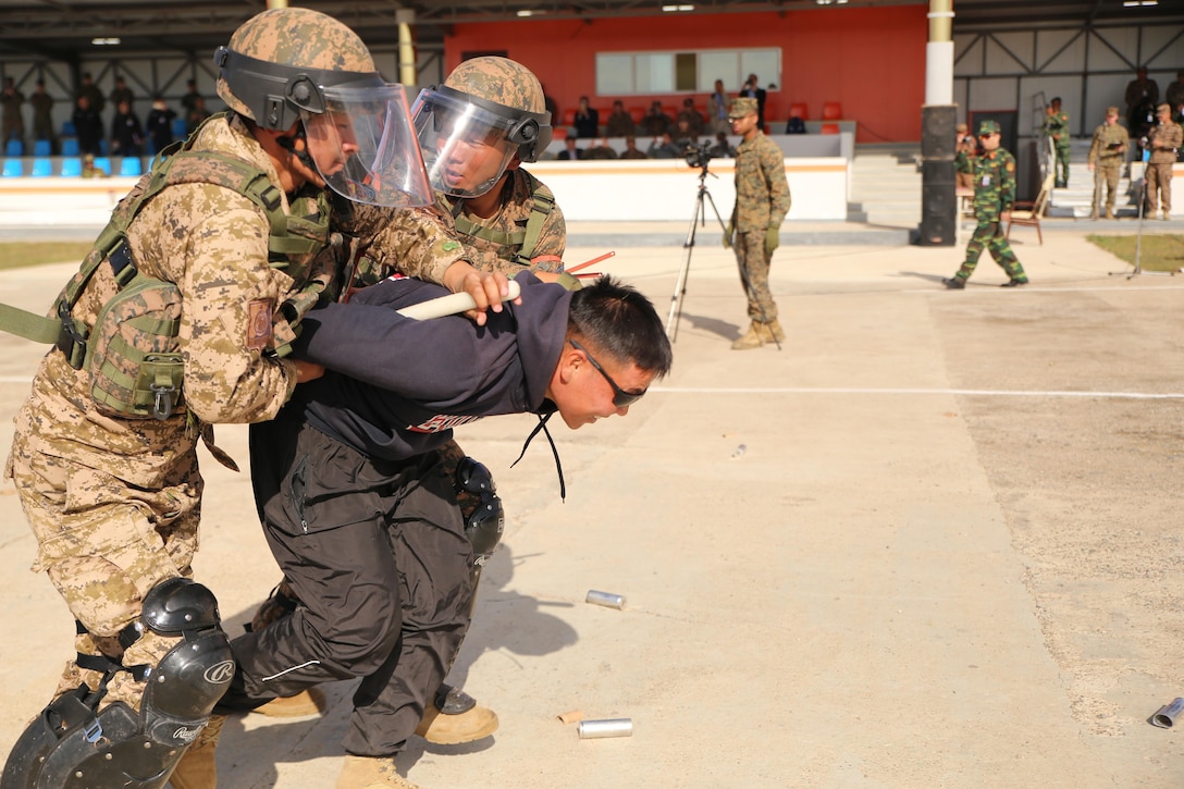 Mongolian Armed Forces soldiers detain a protester during a simulated riot for Non-Lethal Executive Seminar (NOLES) 2016 at the Five Hills Training Area, Mongolia, Sept. 21, 2016. Mongolian soldiers and National Police completed the final portion of the field training exercise for NOLES with several rehearsed scenarios. Non-lethal weapons are designed to incapacitate equipment and personnel while minimizing fatalities and permanent injury to personnel, and undesired collateral damage to property. 