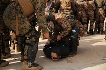 A Mongolian Armed Forces soldier detains a protester with the assistance of a U.S. Marine with 3rd Law Enforcement Battalion, III Marine Expeditionary Force, during a simulated riot for Non-Lethal Executive Seminar (NOLES) 2016 final demonstration at Five Hills Training Area, Mongolia, Sept. 21, 2016. Mongolian soldiers and National Police completed the final portion of the field training exercise for NOLES with several rehearsed scenarios. Non-lethal weapons are designed to incapacitate equipment and personnel while minimizing fatalities and permanent injury to personnel, and undesired collateral damage to property. 