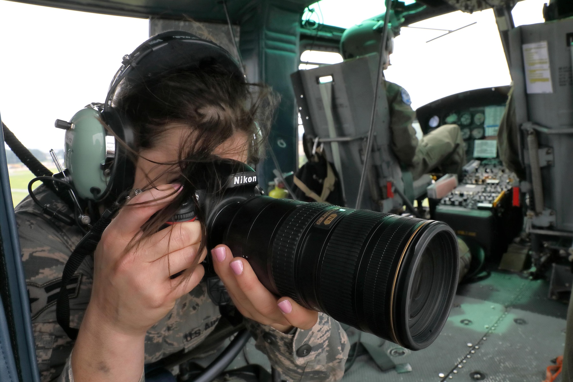 Airman 1st Class Elizabeth Baker, 374th Airlift Wing public affairs photojournalist, captures aerial photographs over Yokota Air Base, Japan, Sept. 17, 2016, during the 2016 Japanese-American Friendship Festival. Yokota welcomed over 135,000 visitors to the festival. (U.S. Air Force photo by Yasuo Osakabe/Released)  