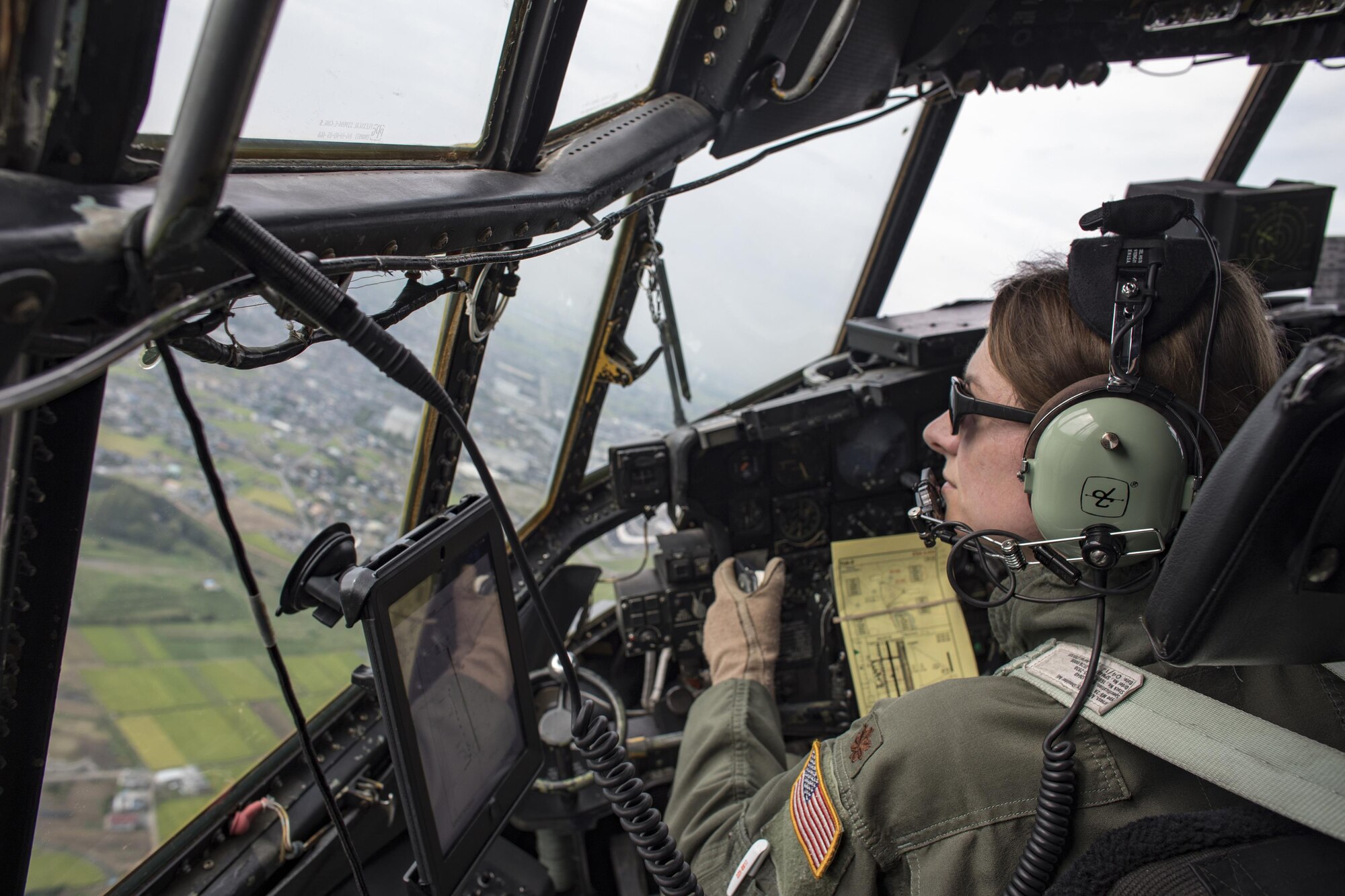 Maj. Dominique Haig, 36th Airlift Squadron chief of standardization and evaluation evaluator C-130 Hercules pilot, flies over the Kanto plains, Japan, during the 2016 Friendship Festival, Sept. 17, 2016. The 36 AS demonstrated their airdrop capabilities to festivalgoers. Yokota welcomed over 135,000 visitors for the festival. (U.S. Air Force photo by Yasuo Osakabe/Released)  