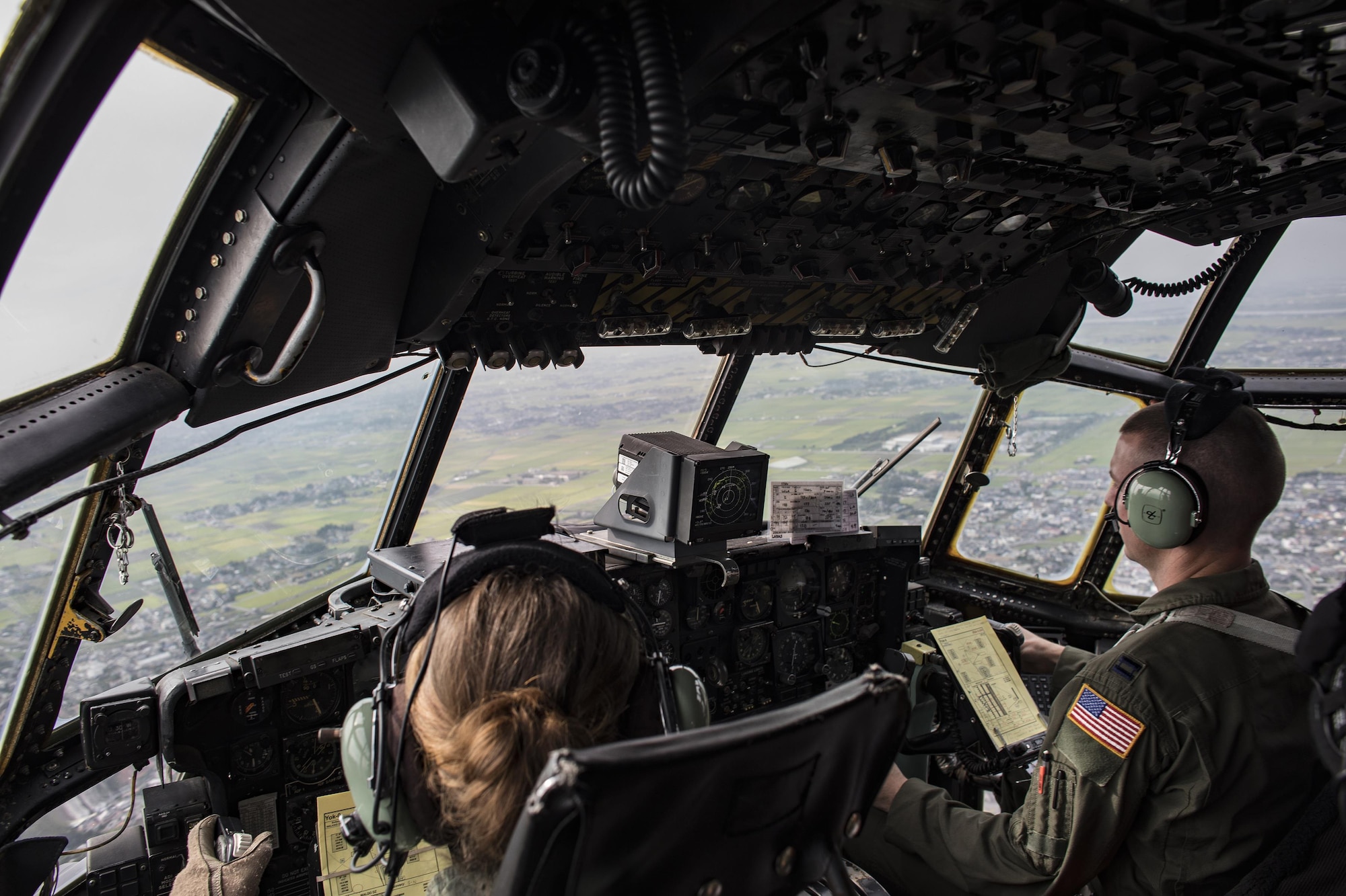 Maj. Dominique Haig and Capt, Bryan Gibbs, 36th Airlift Squadron C-130 Hercules pilots, fly over the Kanto plains, Japan, Sept. 17, 2016, during the 2016 Japanese-American Friendship Festival. The 36 AS demonstrated their airdrop capabilities to festivalgoers. Yokota welcomed over 135,000 visitors for the festival. (U.S. Air Force photo by Yasuo Osakabe/Released)   