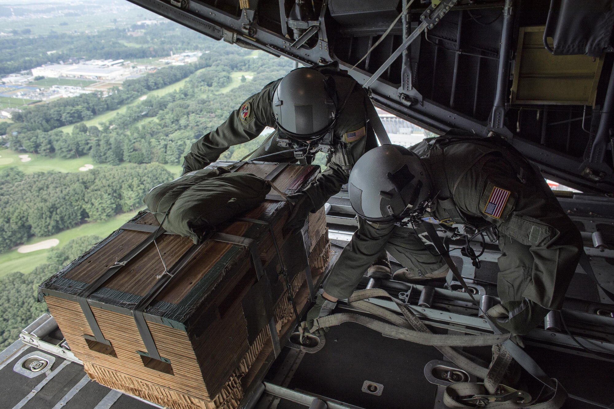 Senior Airman Andrew Fox and Tech. Sgt. Kyle Favorite, 36th Airlift Squadron C-130 Hercules loadmasters, check a low-cost, low-altitude bundle over Yokota Air Base, Japan, Sept. 17, 2016, during the American-Japanese Friendship Festival. The 36 AS demonstrated their airdrop capabilities to festivalgoers. Yokota welcomed over 135,000 visitors for the festival. (U.S. Air Force photo by Yasuo Osakabe/Released)   