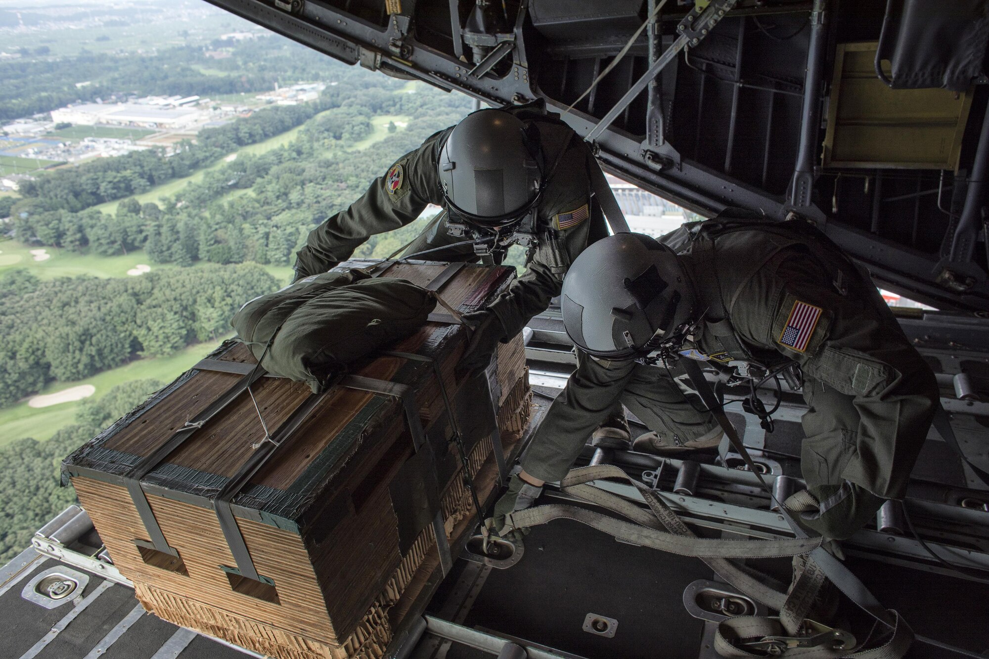 Senior Airman Andrew Fox and Tech. Sgt. Kyle Favorite, 36th Airlift Squadron C-130 Hercules loadmasters, check a low-cost, low-altitude bundle over Yokota Air Base, Japan, Sept. 17, 2016, during the American-Japanese Friendship Festival. The 36 AS demonstrated their airdrop capabilities to festivalgoers. Yokota welcomed over 135,000 visitors for the festival. (U.S. Air Force photo by Yasuo Osakabe/Released)   