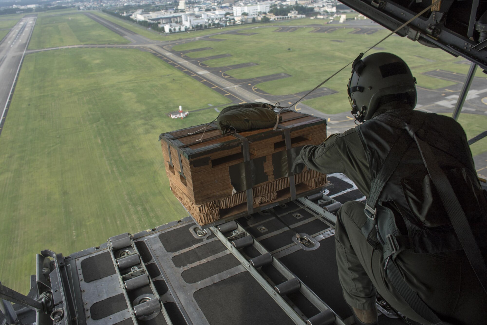 Senior Airman Andrew Fox, 36th Airlift Squadron C-130H loadmaster, drops a low-cost, low-altitude bundle over Yokota Air Base, Japan, Sept. 17, 2016, during the 2016 Japanese-American Friendship Festival. The 36 AS demonstrated their airdrop capabilities to festivalgoers. Yokota welcomed over 135,000 visitors for the festival. (U.S. Air Force photo by Yasuo Osakabe/Released)   