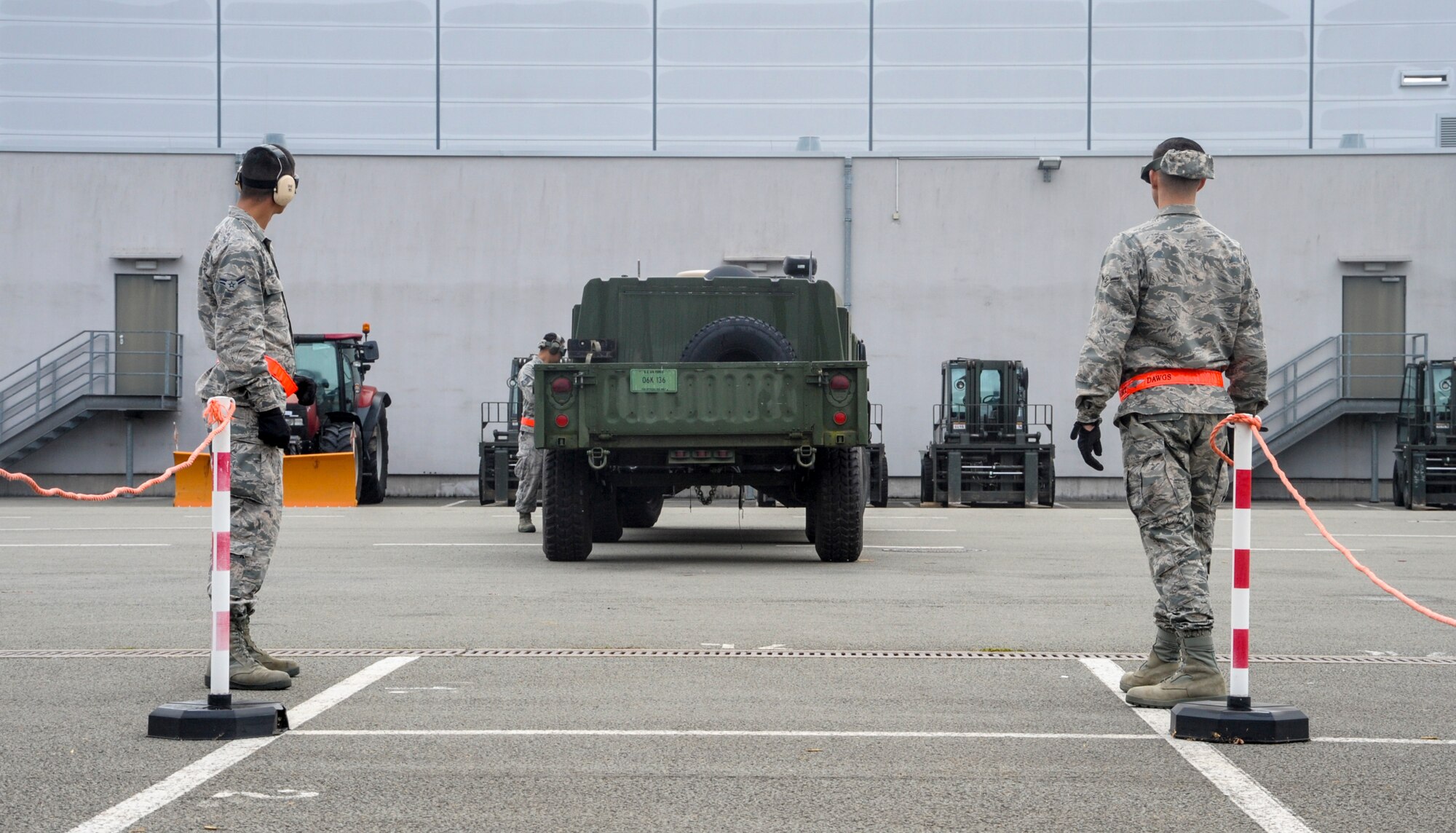 Airmen from the 86th Logistics Readiness Squadron help navigate a vehicle and trailer into a parking spot during the 2016 European Port Dawg Rodeo Sept. 17, 2016, at Ramstein Air Base, Germany. The exercise was conducted to simulate guiding a C-130J Super Hercules onto a ramp after landing. Airmen from the 86th Airlift Wing, 435th Air Ground Operations Wing and 521st Air Mobility Operations Wing competed in physical activities related to their job to earn bragging rights as being the best of the best. (U.S. Air Force photo/Staff Sgt. Timothy Moore)