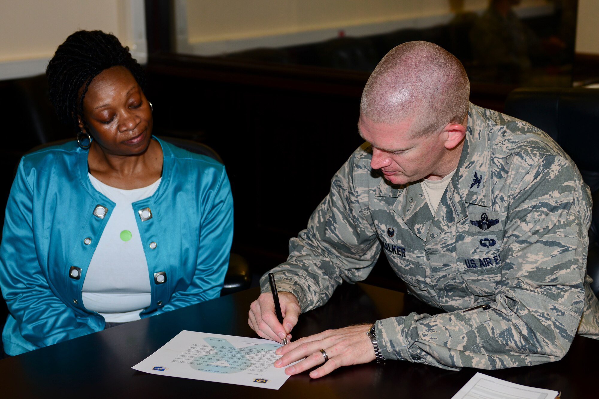 Shelia Bacon, 39th Air Base Wing sexual assault prevention and response (SAPR) victim advocate, oversees U.S. Air Force Col. John Walker, 39th ABW commander, as he signs the SAPR proclamation April 7, 2016, at Incirlik Air Base, Turkey. Bacon was selected as the U.S. Air Forces in Europe and Air Forces Africa 2016 National Image, Inc. Civilian Meritorious Service Award winner. (U.S. Air Force photo by Staff Sgt. Caleb Pierce/Released)