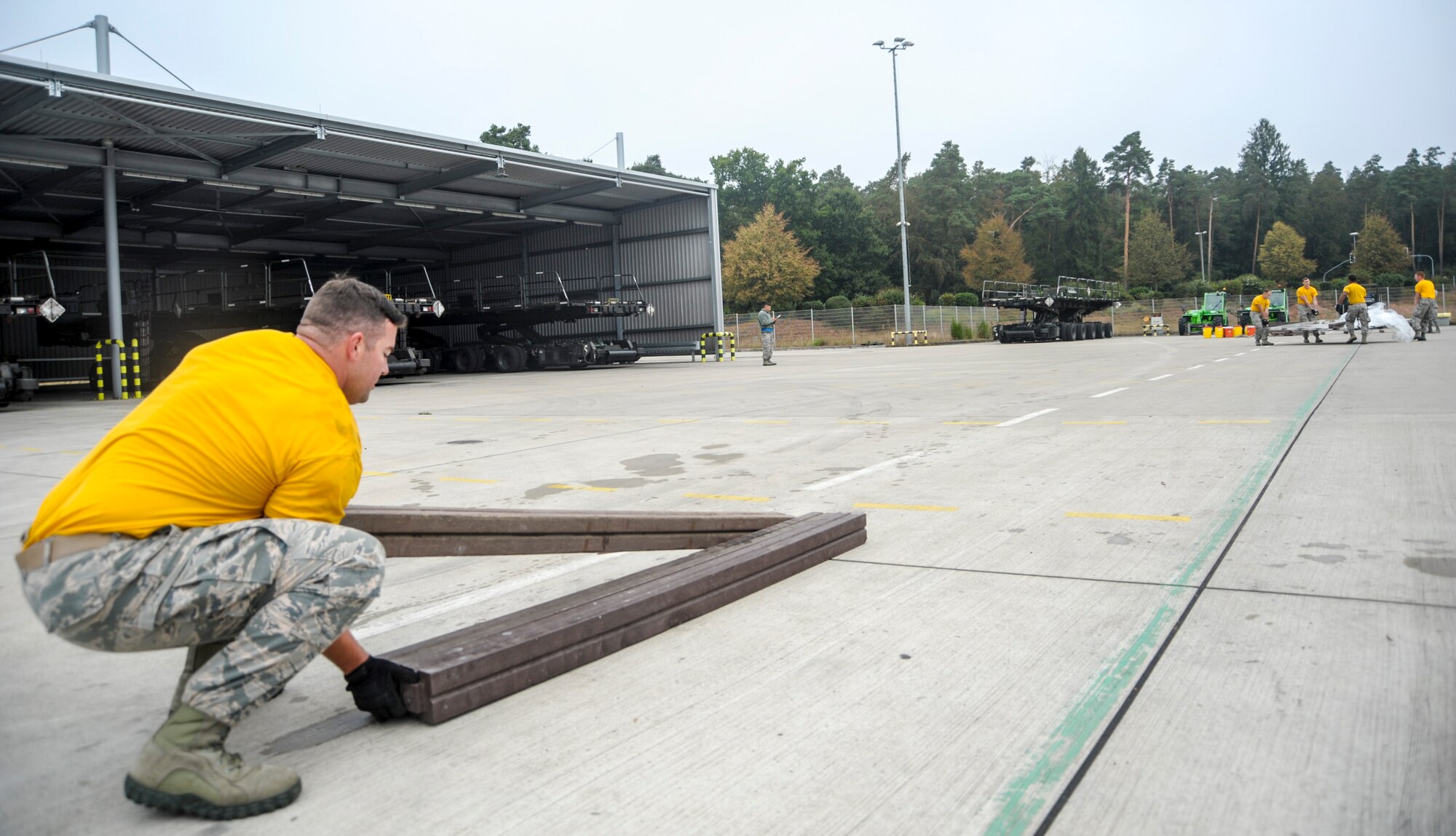 Staff Sgt. Benjamin Patton, 435th Contingency Response Squadron mobile aerial porter, lifts the last pieces of dunnage as the rest of his team moves a pallet during the physical challenge obstacle course of the 2016 European Port Dawg Rodeo Sept. 17, 2016, at Ramstein Air Base, Germany. During the course, Airmen had to unload a pallet, move the items and pallet approximately 100 yards away, rebuild the pallet and run a relay around an apron. (U.S. Air Force photo/Staff Sgt. Timothy Moore)
